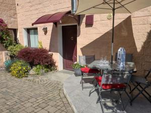 un tavolo e sedie con un ombrellone in un patio di La Maison Rose CIR 0244 ad Aosta