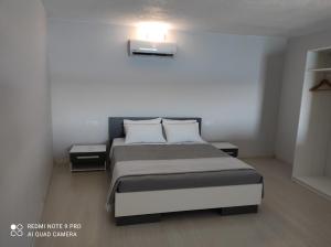 a bedroom with a bed with two tables and a light at Marilia apartment in Agios Nikolaos