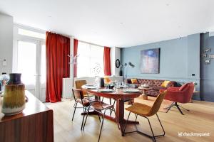 uma sala de jantar e sala de estar com mesa e cadeiras em CMG - Le Marais / Place des Vosges em Paris