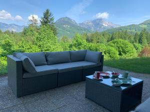 eine Couch auf einer Terrasse mit einem Tisch in der Unterkunft FeWo Zeitlos in Berchtesgaden