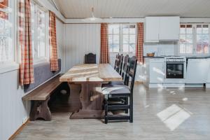 uma cozinha com uma mesa de madeira e cadeiras num quarto em Hovden Høyfjellsenter em Hovden
