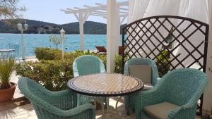una mesa y sillas en un patio con vistas al agua en Apartments Antonio, en Tisno
