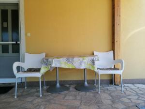 比利塞的住宿－Apartments Marko，一张桌子,三把椅子坐在墙上