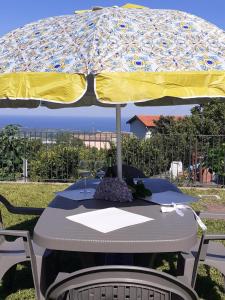 a table with a yellow and blue umbrella at Il Limoneto di Leo in Mascali