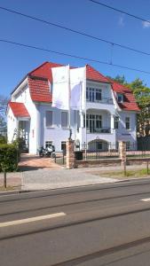 een groot wit huis met een rood dak bij Haus am See in Berlijn