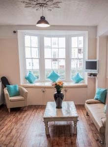 a living room with a couch and a table and a window at Horizon in Brighton & Hove