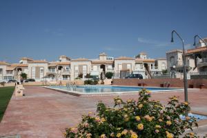 une villa avec une piscine en face d'un bâtiment dans l'établissement Altos de la Bahia 83, à Torrevieja