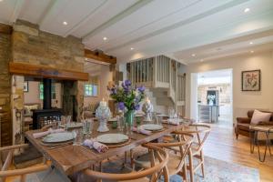 een eetkamer met een lange houten tafel en stoelen bij Colebrook Cottage in Blockley