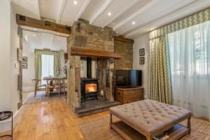 a living room with a fireplace and a television at Colebrook Cottage in Blockley