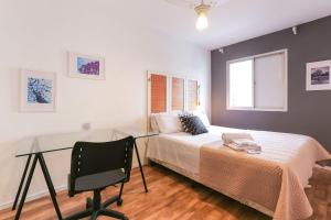 a bedroom with a bed and a desk and a chair at Apartamento espaçoso em Pinheiros ao lado do metrô in Sao Paulo