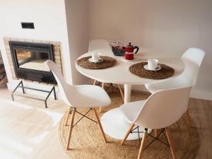 una mesa y sillas en una sala de estar con chimenea en Alojamiento ISLA BONITA con balcón vista al mar en Breña Baja