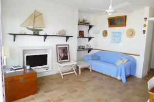 a living room with a blue bed and a tv at Fragata Beach Seaview in Sitges