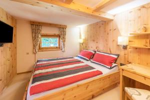 a bedroom with a large bed with red pillows at Chalet Zur Auszeit in Aschau +31 photos