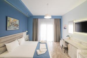 a hotel room with a bed and a tv at Villa Nickolas in Paleo Tsifliki