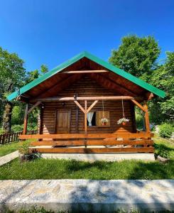 domek z bali z zielonym dachem w obiekcie Cabin House Dubovik w mieście Cetynia