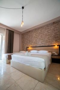 a bedroom with two beds and a brick wall at Villa Nickolas in Paleo Tsifliki