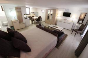 a bedroom with a large bed and a living room at WATERFRONT VILLA SUNSET DREAM WITH POOL in Trebinje