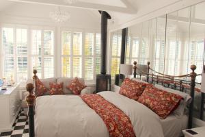 ein Schlafzimmer mit einem großen Bett mit roten Kissen in der Unterkunft Croft House Guest Suite Painswick in Painswick