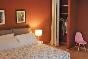 拉斯佩齊亞的住宿－Cinque Terre The Arcade Apartment - Two bathrooms，一间卧室配有一张床和一张粉红色的椅子