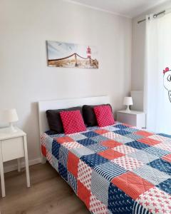 ウストロニエ・モルスキエにあるApartament Ku Morzu Ustronie Morskieのベッドルーム1室(青と赤のキルトのベッド1台付)