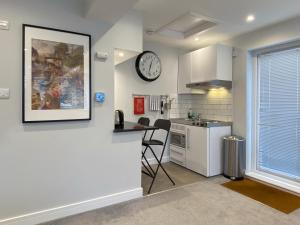 a kitchen with a counter and a clock on the wall at THE STUDIO MAIDENHEAD RIVERSIDE in Maidenhead