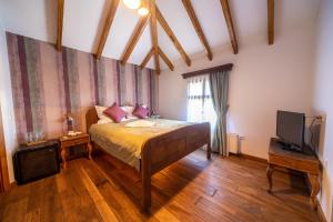 um quarto com uma cama e uma televisão em Woodland Resort em Kragujevac