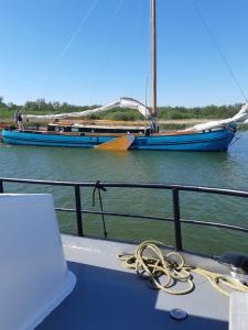 een boot met touwen op het dek met twee boten in het water bij Woontjalk Bûten Ferwachting in Makkum