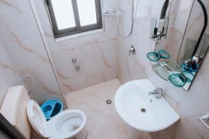 a bathroom with a toilet and a sink and a shower at Hotel Perdja in Velipojë
