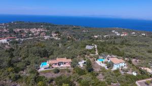 una vista aerea di una casa su una collina vicino all'oceano di Villa Belvedere Rosa a Tsoukalades