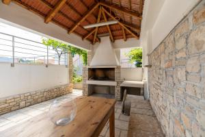 a room with a stone wall and a wooden table at Villa Gradina in Vela Luka