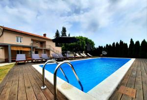 a pool with chairs and an umbrella next to a house at Holiday house in Central Istria with private pool in Žminj
