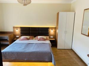 ミシュコルツ・タポルツァにあるHarmónia Vendégházのベッドルーム1室(大型ベッド1台、白いキャビネット付)
