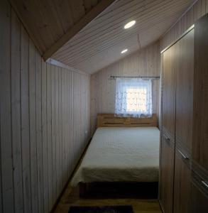 ケダイネイにあるKėdainiai Old town apartmentのベッドと窓が備わる小さな客室です。