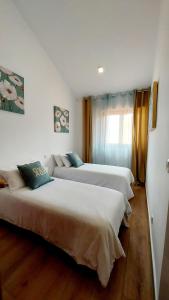 エル・カンページョにあるSunny Duplex in front of Campello beachのベッド2台とソファのある部屋