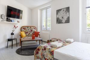 1 dormitorio con 1 cama y 1 silla en Travel Homes - L'Alsacien, près de la ville, en Mulhouse
