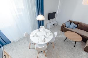 ein Wohnzimmer mit einem Tisch, Stühlen und einem Sofa in der Unterkunft Resort Apartamenty Klifowa Rewal 59 in Rewal