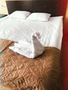 a bed with a pile of towels on it at Hotel Kremlevsky in Ryazan