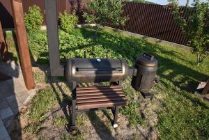 a grill and a trash can sitting in the grass at Мигдаль Маєток in Svityazʼ