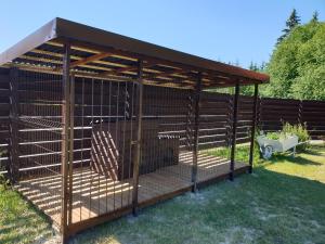 a large brown bird cage in a yard at Kukoriškių nameliai in Kukoriškiai