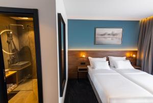 a hotel room with two beds and a shower at Boutique ROOMs 76 in Imotski