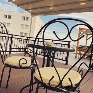 a pair of chairs and a table on a balcony at Overwave Apartment in Kavála