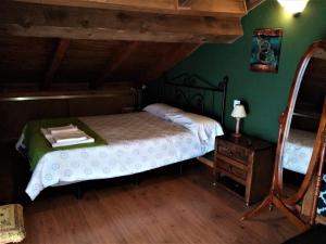 a bedroom with a bed and a dresser and green walls at La torna in Navarredonda de Gredos