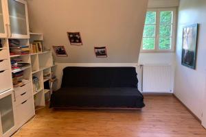 a bedroom with a black bed in a room at Studio indépendant dans maison neuve in Senlis