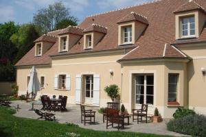 a house with chairs and tables in front of it at Studio indépendant dans maison neuve in Senlis