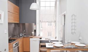 een keuken met een tafel met witte borden erop bij Royal Mile Apartment in Edinburgh