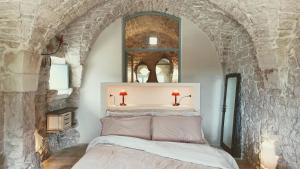 a bedroom with a bed with a stone wall at Masseria LoJazzo in Ceglie Messapica