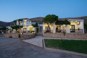 a house with a stone wall and a driveway at Adam in Falasarna +61 photos