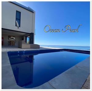 a swimming pool in front of a house at Ocean pearl seafront villa in St. Helena Bay