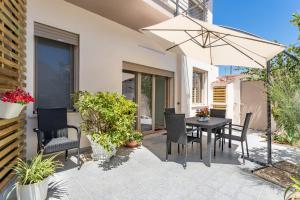 卡布拉斯的住宿－CASA L'ANGOLO FIORITO，庭院配有桌椅和遮阳伞。