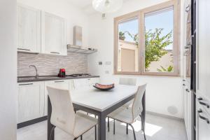 卡布拉斯的住宿－CASA L'ANGOLO FIORITO，厨房配有桌椅和窗户。